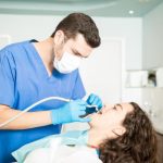 dentist performing fluoride treatment to strengthen tooth enamel and prevent decay.