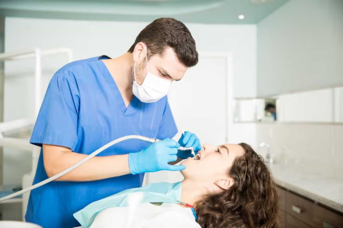 dentist performing fluoride treatment to strengthen tooth enamel and prevent decay.