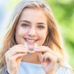 woman holding invisalign aligners